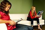 2 women reading on sofa