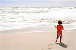 Petit garçon sur la plage tenant une épuisette, à l'extérieur