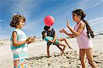 Eltern und zwei Kinder spielen am Strand, im freien