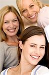 Three women smiling for the camera, indoors