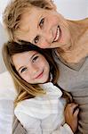 Senior woman and little girl smiling for the camera, indoors