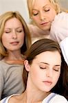 Three women with eyes-closed, indoors