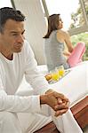 Couple sitting on bed, indoors