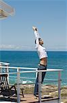 Young man stretching, seafront, outdoors