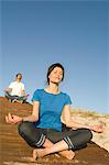 Young couple in yoga attitude, outdoors