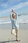 Woman in yoga attitude on the beach, outdoors