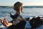 Jeune femme à l'attitude d'yoga sur la plage, en plein air