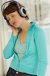 Portrait of a young woman, listening to music with headphones