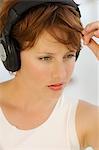 Porträt einer jungen Frau, die mit Kopfhörern Musik hören