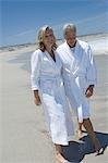 Couple in bathrobe walking on the beach