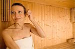 Senior woman combing her hair in sauna