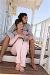 Couple souriant assis sur la terrasse en bois