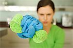 Young woman wringing sponge