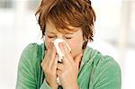 Portrait of young woman blowing her nose