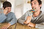 Father eating lollipop with his son