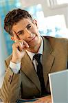 Mid adult businessman sitting in office, portrait