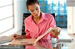 Businesswoman reading newspaper in office