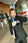 Young businessman looking at wristwatch