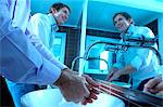 Businessmen washing hands in washroom, smiling