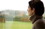 Mid adult woman looking out through a window