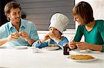 Mid adult man and a young woman having breakfast with their son