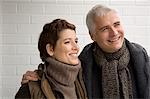 Close-up of a mature man arm around a mid adult woman and smiling