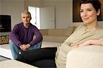 Mid adult woman and a mature man sitting in a living room