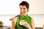 Portrait d'une femme adulte mid manger avec des baguettes