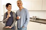 Homme mûr et une femme adulte mid tenant des verres de lait