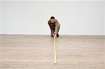 Interior designer measuring the hardwood floor with a tape measure