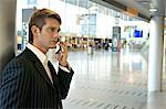 Side profile of a businessman talking on a mobile phone at an airport