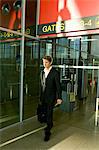 Businessman walking with his luggage at an airport