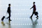 Vue grand angle des deux hommes marchant dans un hall d'aéroport