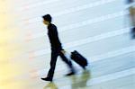 Vue d'angle élevé d'un homme tirant ses bagages à un hall de l'aéroport