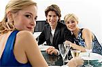 Two young women with a teenage boy at a dinner party