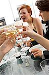 Close-up of human hands toasting with champagne at a dinner party