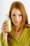 Portrait d'une jeune femme tenant une bouteille d'huile aromathérapie