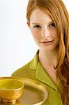 Portrait d'une jeune femme tenant un bol d'huile de massage sur une plaque