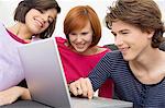 Gros plan des deux jeunes femmes et un adolescent sur un ordinateur portable