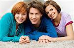 Portrait of a teenage boy smiling with two young women
