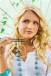 Young woman holding chopsticks and umbrella