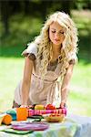 Young woman setting table outdoors