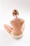 Rear view of a woman massaging her shoulders