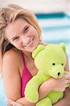 Portrait of a woman holding a teddy bear and smiling