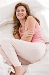 Woman resting on the bed and smiling