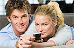 Portrait of a couple holding a remote control and smiling