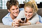 Couple holding a remote control and smiling