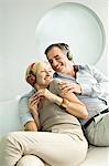 Couple à l'écoute de musique avec un casque et souriant