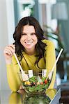 Portrait of a woman mixing salad