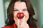 Woman holding a nectarine in front of her nose